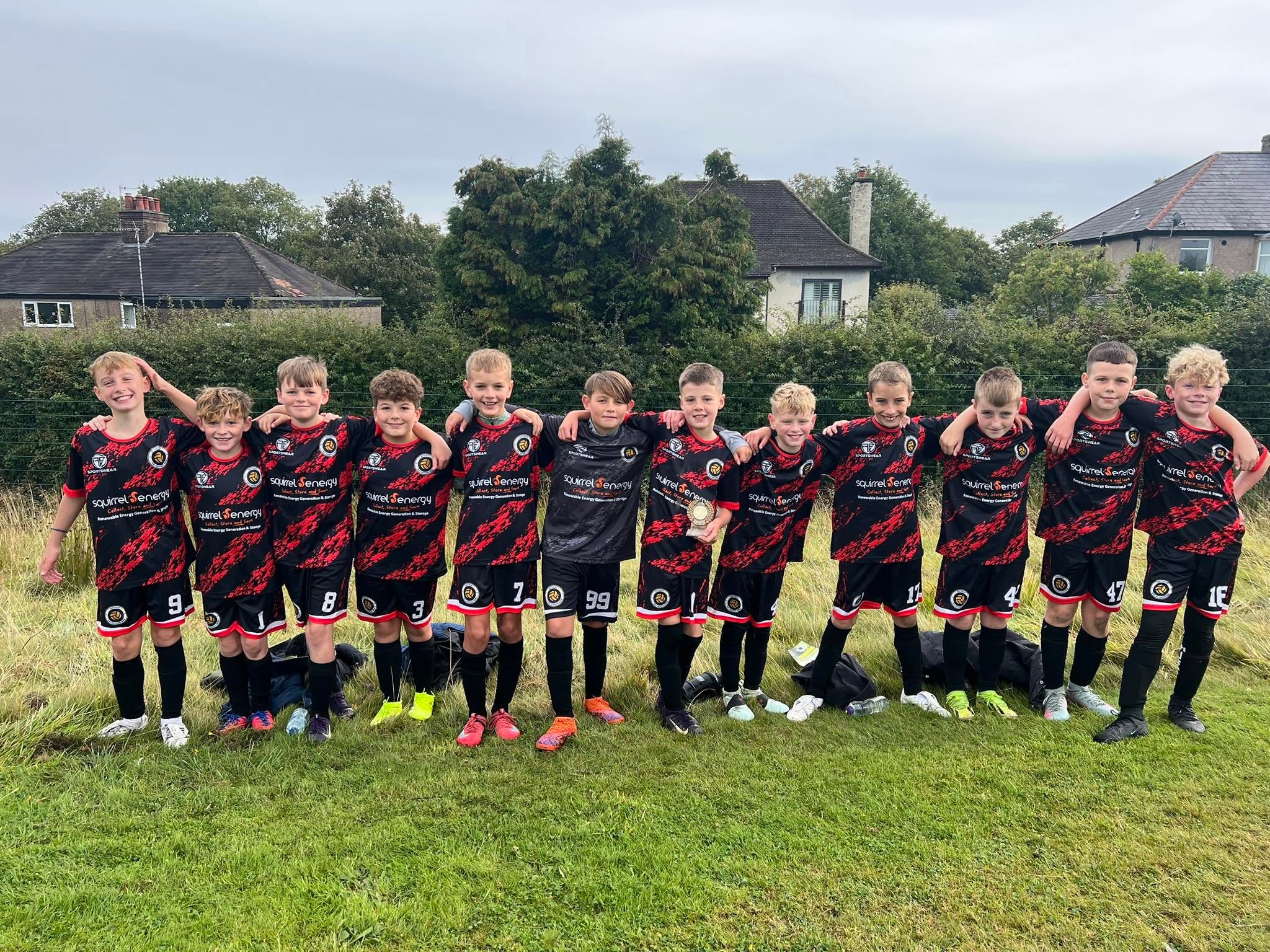 Squirrel Energy sponsored youth football team in black and red kits