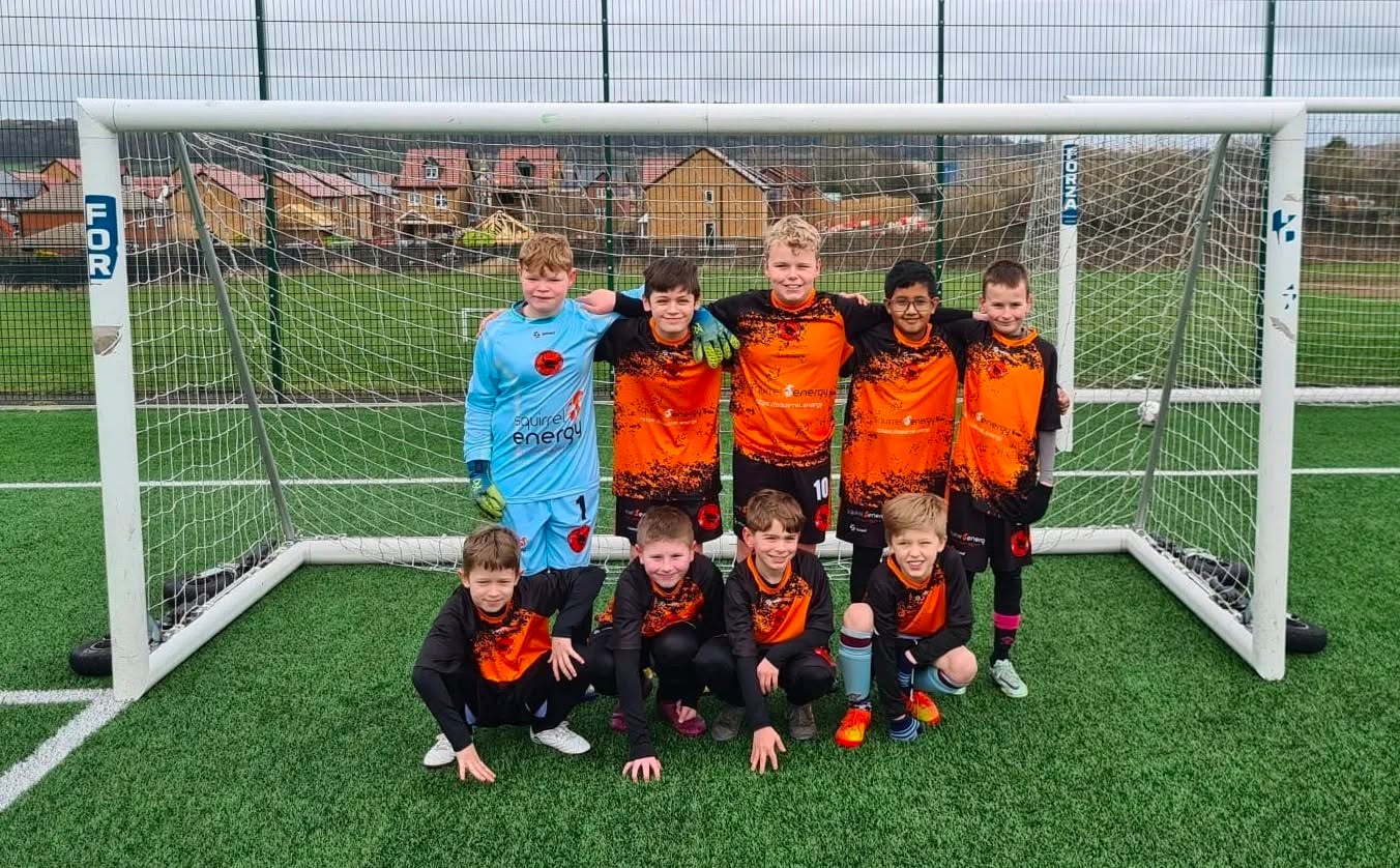 Squirrel Energy sponsored youth football team in orange and black kits