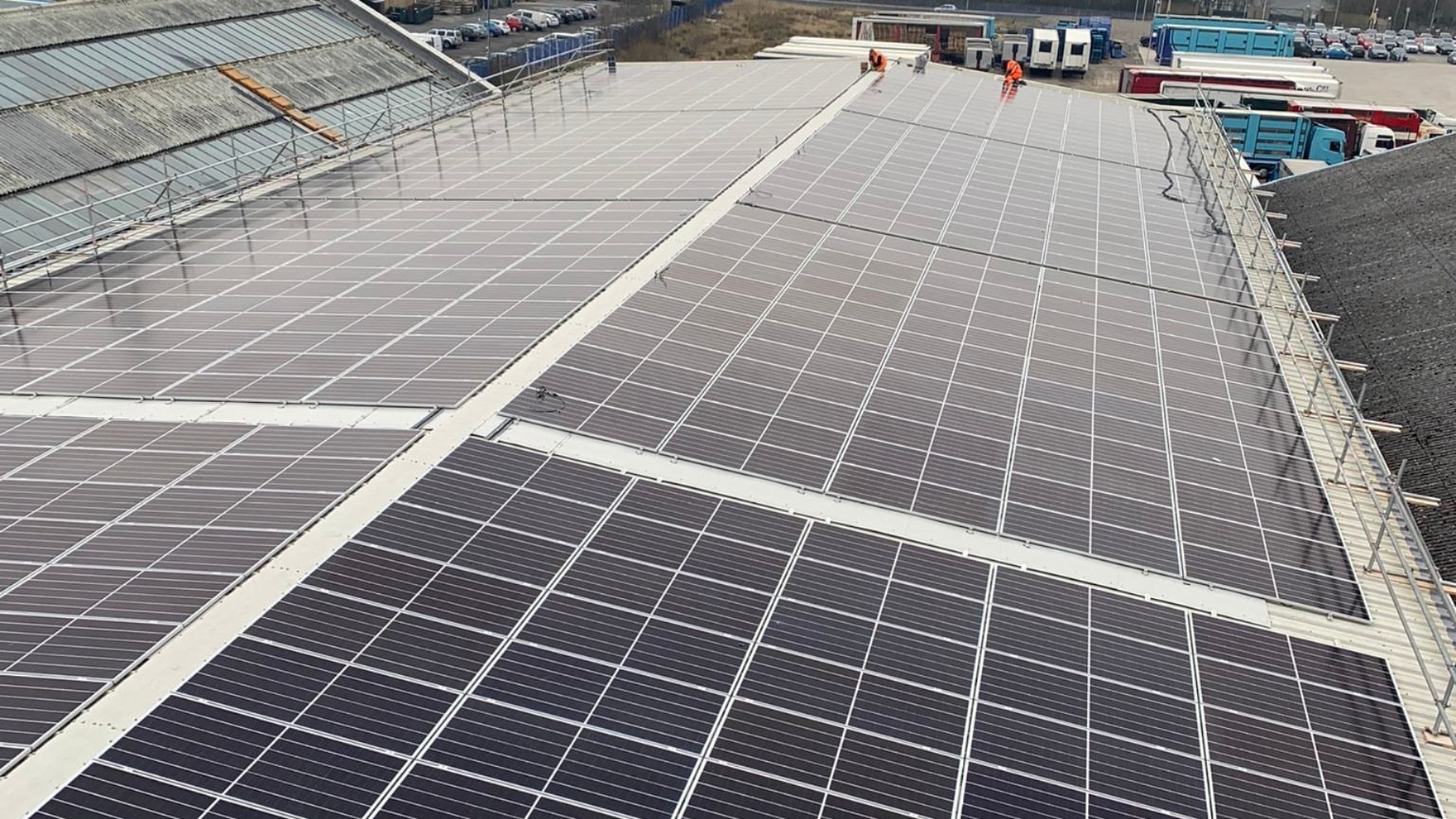 Aerial view of large factory roof covered in solar panels